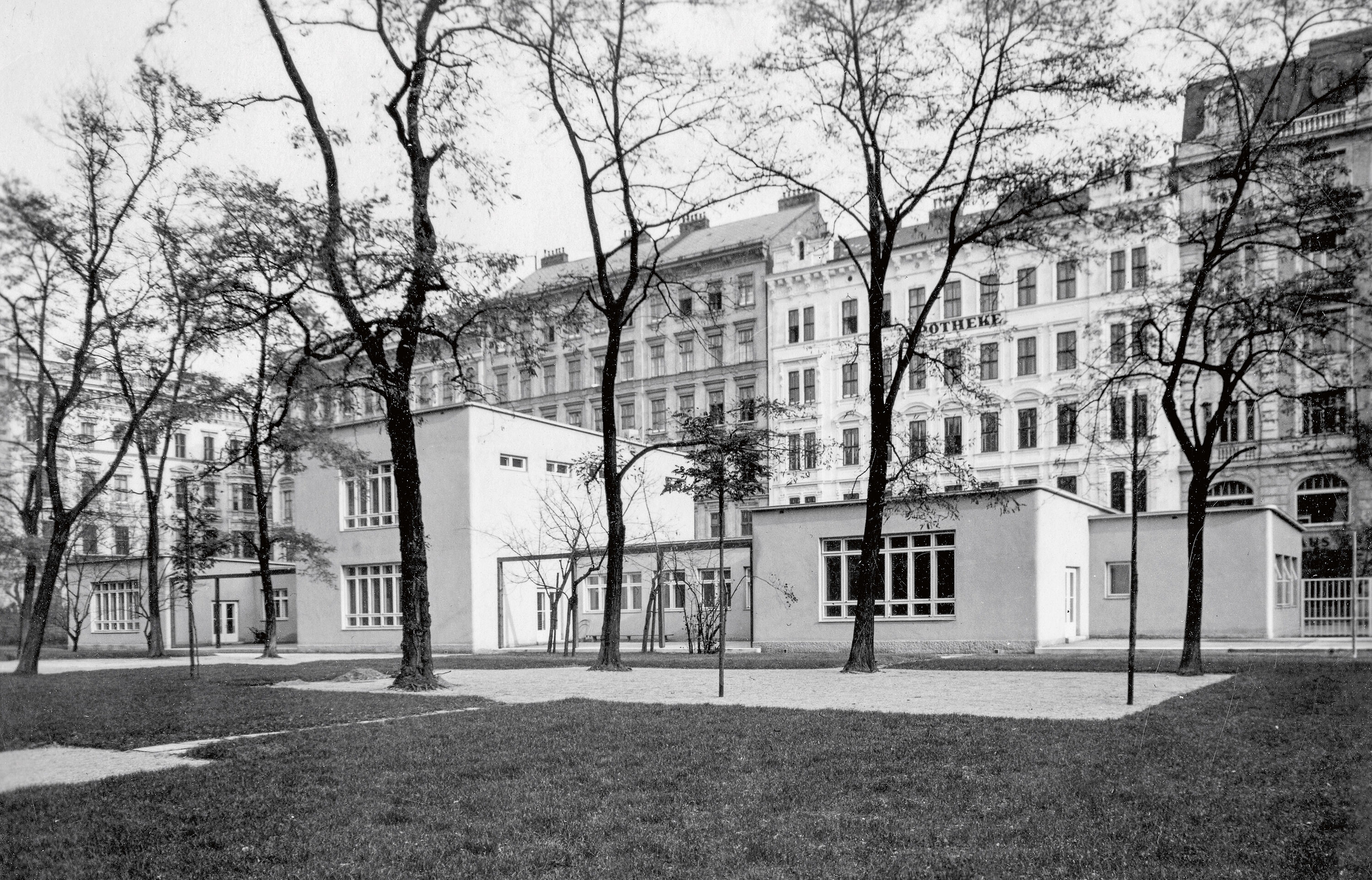 A black and white photograph shows the puristic building shortly after its completion around 1930; there are trees in the foreground.